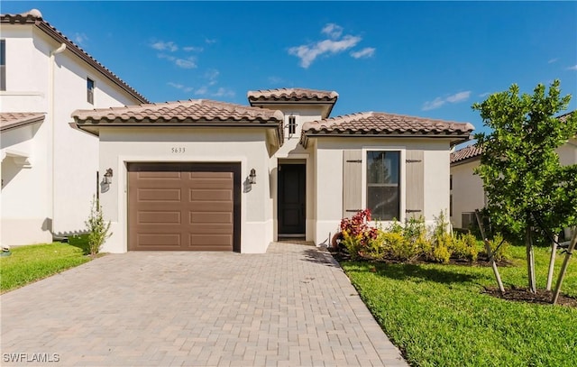 5633 Cassidy Ln, Ave Maria, FL 34142 - mediterranean / spanish-style home featuring a garage, decorative driveway, a tiled roof, and stucco siding