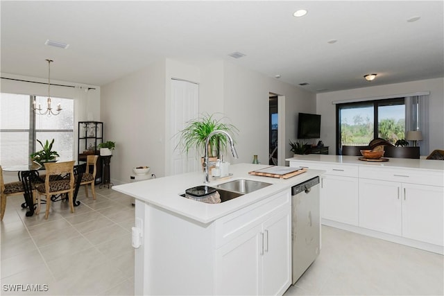 5633 Cassidy Ln, Ave Maria, FL 34142 - kitchen with stainless steel dishwasher, a sink, a chandelier, a kitchen island with sink, and light countertops