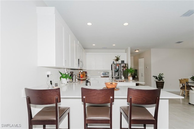 5633 Cassidy Ln, Ave Maria, FL 34142 - kitchen featuring a peninsula, stainless steel appliances, light countertops, a breakfast bar, and a sink