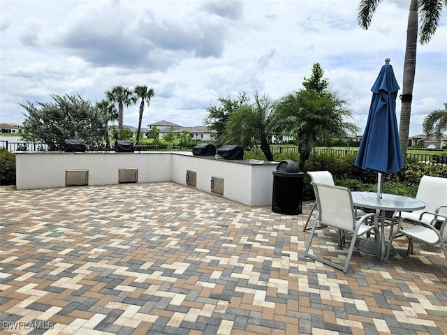 5633 Cassidy Ln, Ave Maria, FL 34142 - view of patio / terrace featuring fence, an outdoor kitchen, and outdoor dining space