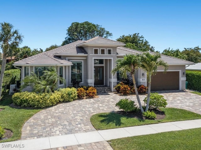 811 Manor Ter, Marco Island, FL 34145 - prairie-style house with a tile roof, decorative driveway, a garage, and stucco siding