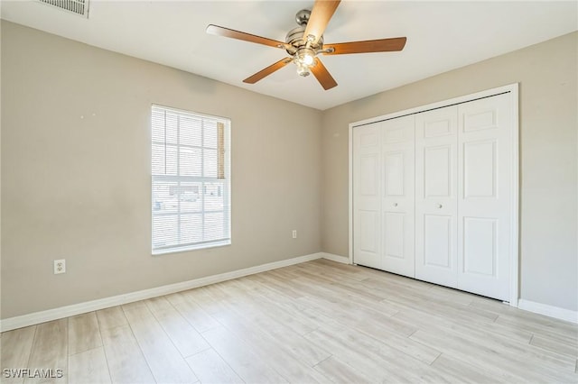 3406 27th St SW, Lehigh Acres, FL 33976 - unfurnished bedroom with light wood-style flooring, baseboards, a closet, and ceiling fan