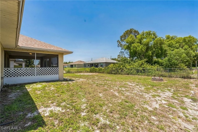 3406 27th St SW, Lehigh Acres, FL 33976 - view of yard featuring a sunroom and an outdoor fire pit