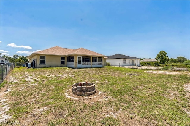 3406 27th St SW, Lehigh Acres, FL 33976 - back of house featuring an outdoor fire pit, central AC unit, and a sunroom