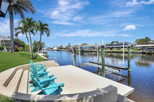 dock with boat lift, a water view, and a yard