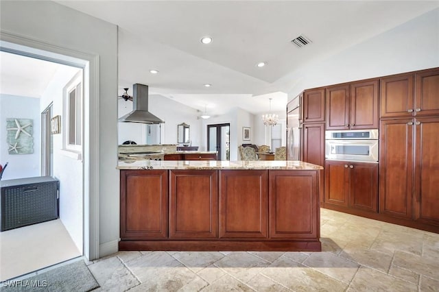 kitchen featuring extractor fan, stainless steel oven, a peninsula, a chandelier, and light stone countertops