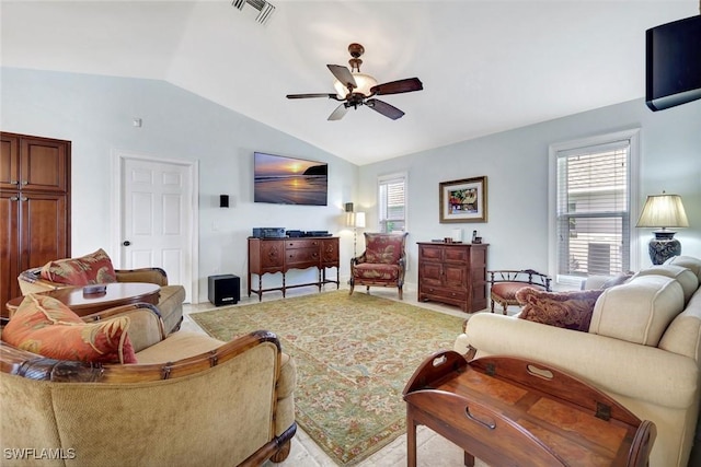 living area with lofted ceiling, a ceiling fan, and healthy amount of natural light