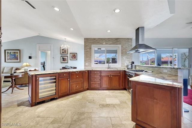 kitchen featuring a peninsula, extractor fan, beverage cooler, vaulted ceiling, and high end stove