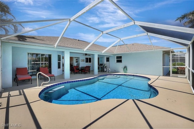 swimming pool with a patio area, ceiling fan, and glass enclosure