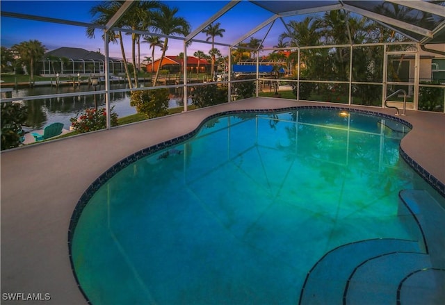 outdoor pool with a water view, a patio, and glass enclosure