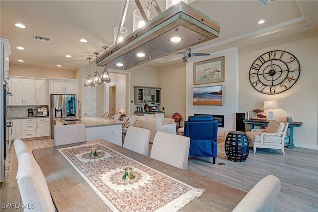 9292 Cayman Dr, Naples, FL 34114 - dining area with light wood-style floors, recessed lighting, a fireplace, a chandelier, and baseboards