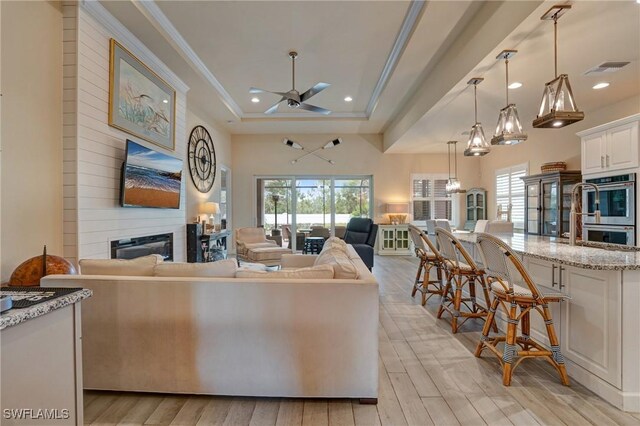 9292 Cayman Dr, Naples, FL 34114 - living room with a ceiling fan, a fireplace, recessed lighting, light wood-type flooring, and ornamental molding