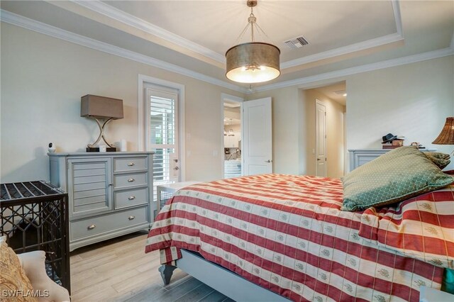 9292 Cayman Dr, Naples, FL 34114 - bedroom featuring light wood-style flooring, a raised ceiling, and ornamental molding