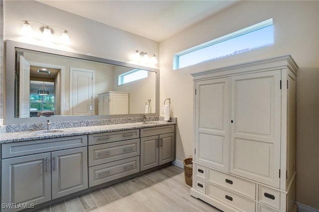 9292 Cayman Dr, Naples, FL 34114 - bathroom with double vanity, wood finished floors, and baseboards