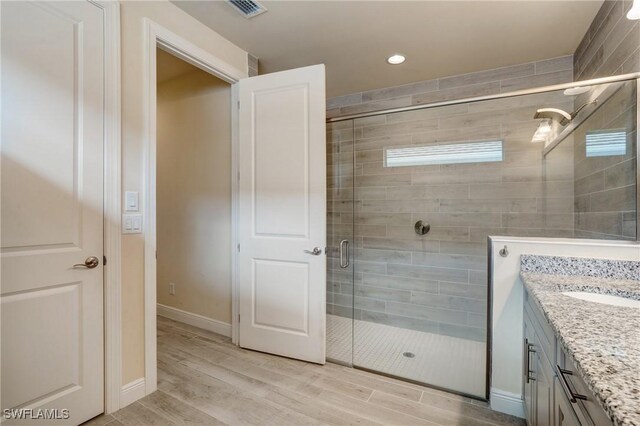 9292 Cayman Dr, Naples, FL 34114 - full bathroom with a shower stall, vanity, wood finished floors, recessed lighting, and baseboards