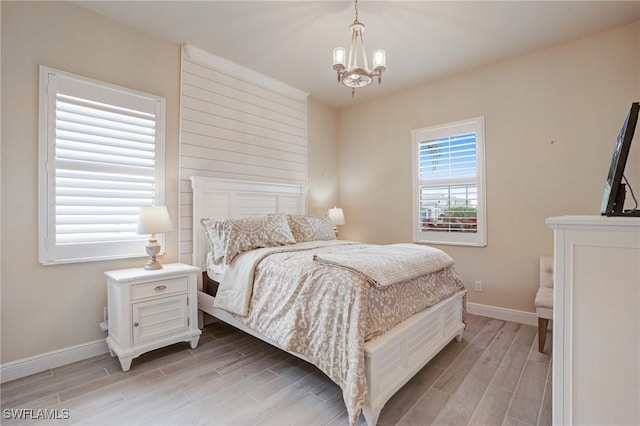 9292 Cayman Dr, Naples, FL 34114 - bedroom with light wood-style floors, a chandelier, and baseboards
