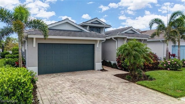 9292 Cayman Dr, Naples, FL 34114 - view of front of home featuring stucco siding, an attached garage, decorative driveway, a tiled roof, and a front yard