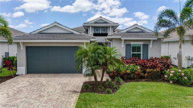 9292 Cayman Dr, Naples, FL 34114 - view of front facade with stucco siding, decorative driveway, a garage, a front lawn, and a tiled roof