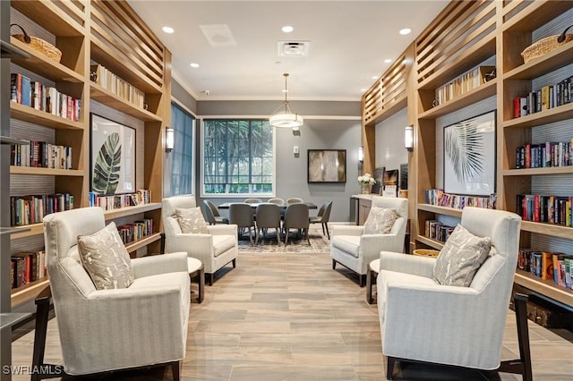 9292 Cayman Dr, Naples, FL 34114 - sitting room featuring crown molding, recessed lighting, light wood-type flooring, and built in shelves