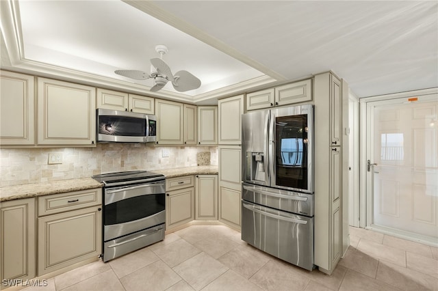 25900 Hickory Blvd Unit 504, Bonita Springs, FL 34134 - kitchen featuring cream cabinets, appliances with stainless steel finishes, a tray ceiling, backsplash, and ceiling fan