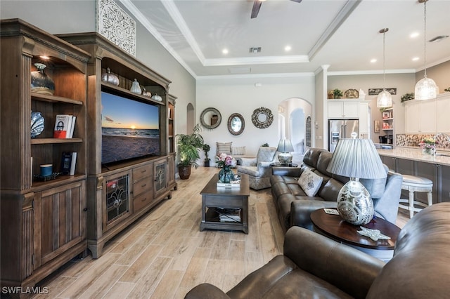 23268 Sanabria Loop, Bonita Springs, FL 34135 - living room with arched walkways, light wood-style floors, a tray ceiling, and crown molding