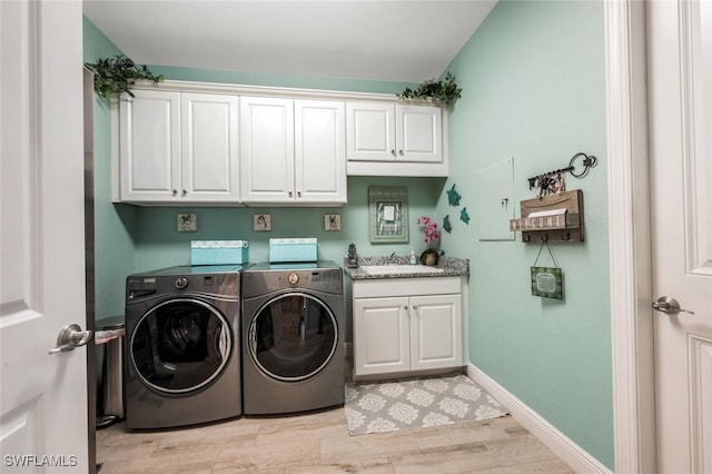 23268 Sanabria Loop, Bonita Springs, FL 34135 - laundry room featuring cabinet space, washer and clothes dryer, light wood-style floors, and baseboards