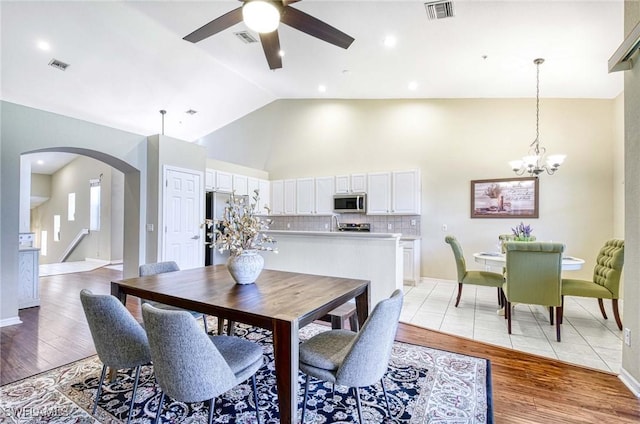 13891 Lake Mahogany Blvd Unit 3123, Fort Myers, FL 33907 - dining room featuring arched walkways, a ceiling fan, light wood-style flooring, a chandelier, and high vaulted ceiling