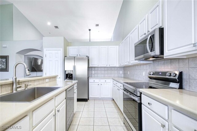 13891 Lake Mahogany Blvd Unit 3123, Fort Myers, FL 33907 - kitchen featuring appliances with stainless steel finishes, a sink, backsplash, white cabinets, and light tile patterned flooring