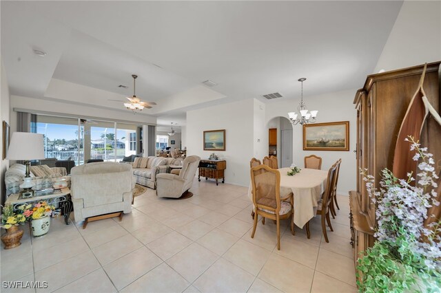2010 SE 13th Ter, Cape Coral, FL 33990 - dining room with a chandelier, light tile patterned floors, a tray ceiling, arched walkways, and a ceiling fan