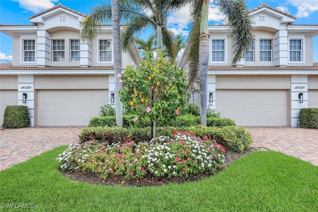 10220 Bellavista Cir Unit 1402, Miromar Lakes, FL 33913 - mediterranean / spanish-style house with a garage, a tile roof, and decorative driveway