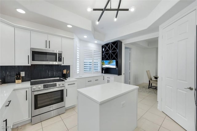 10220 Bellavista Cir Unit 1402, Miromar Lakes, FL 33913 - kitchen with stainless steel appliances, decorative backsplash, light tile patterned flooring, white cabinets, and recessed lighting