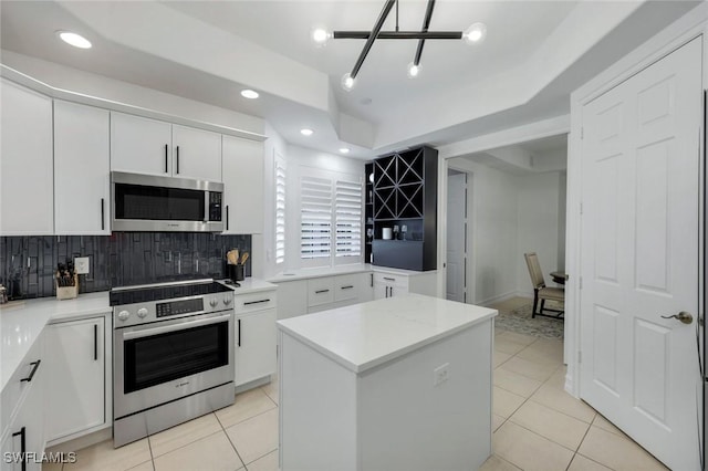 10220 Bellavista Cir Unit 1402, Miromar Lakes, FL 33913 - kitchen featuring appliances with stainless steel finishes, backsplash, light tile patterned floors, white cabinetry, and recessed lighting