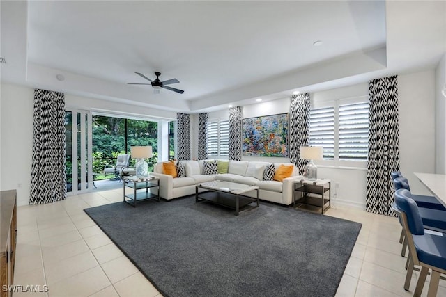 10220 Bellavista Cir Unit 1402, Miromar Lakes, FL 33913 - living area featuring a tray ceiling, light tile patterned flooring, and a ceiling fan