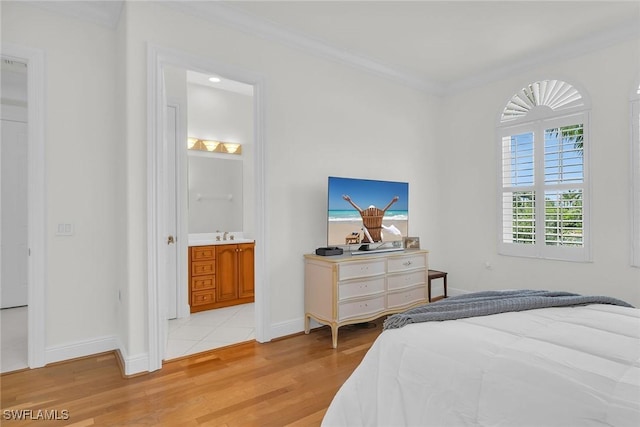 9142 Cherry Oaks Ln Unit 202, Naples, FL 34114 - bedroom featuring light wood-style floors, baseboards, ornamental molding, and connected bathroom