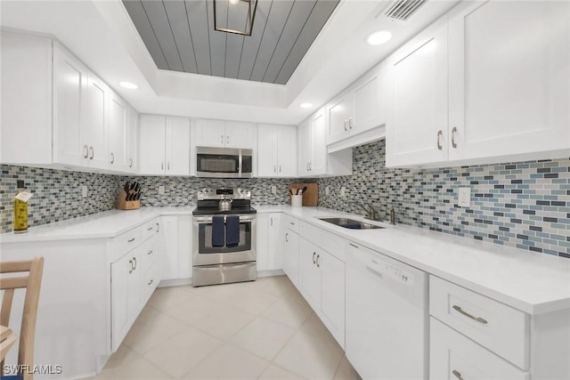 1020 Swallow Ave Unit 102, Marco Island, FL 34145 - kitchen with stainless steel appliances, a sink, light countertops, light tile patterned flooring, and tasteful backsplash