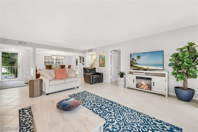 1020 Swallow Ave Unit 102, Marco Island, FL 34145 - tiled living room featuring a chandelier and a glass covered fireplace