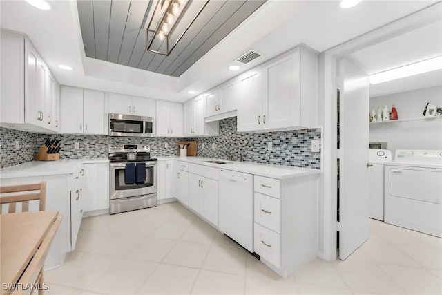 1020 Swallow Ave Unit 102, Marco Island, FL 34145 - kitchen featuring appliances with stainless steel finishes, washing machine and clothes dryer, light countertops, white cabinetry, and recessed lighting