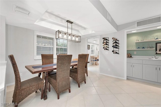 1020 Swallow Ave Unit 102, Marco Island, FL 34145 - dining room with baseboards, light tile patterned floors, a tray ceiling, and a chandelier