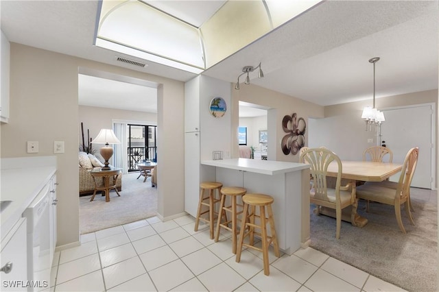 6612 Estero Blvd Unit Ph2, Fort Myers Beach, FL 33931 - kitchen with light colored carpet, a kitchen breakfast bar, light countertops, and light tile patterned flooring