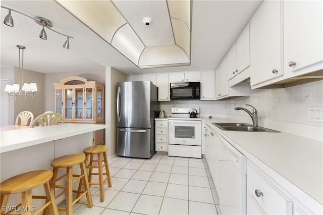 6612 Estero Blvd Unit Ph2, Fort Myers Beach, FL 33931 - kitchen featuring white appliances, a sink, a breakfast bar, light tile patterned floors, and light countertops