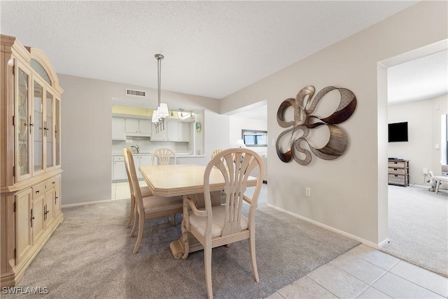 6612 Estero Blvd Unit Ph2, Fort Myers Beach, FL 33931 - dining room with light colored carpet, baseboards, light tile patterned floors, a textured ceiling, and a chandelier