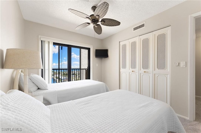 6612 Estero Blvd Unit Ph2, Fort Myers Beach, FL 33931 - bedroom with access to exterior, carpet floors, a closet, a textured ceiling, and ceiling fan