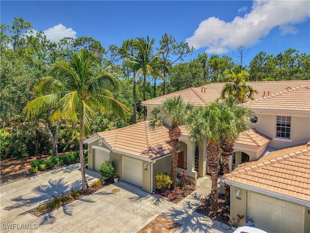 1732 Tarpon Bay Dr S Unit 101, Naples, FL 34119 - mediterranean / spanish home with a tiled roof, driveway, stucco siding, and a garage