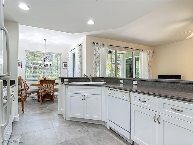 1732 Tarpon Bay Dr S Unit 101, Naples, FL 34119 - kitchen with white dishwasher, a sink, dark countertops, a chandelier, and healthy amount of natural light