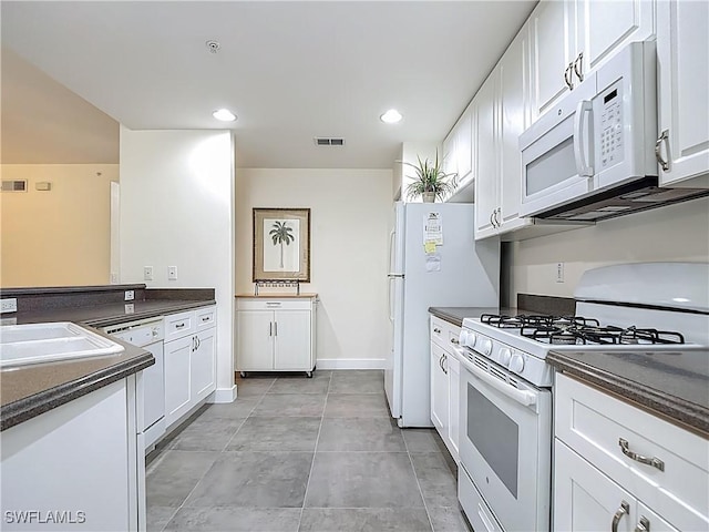 1732 Tarpon Bay Dr S Unit 101, Naples, FL 34119 - kitchen with white appliances, dark countertops, white cabinets, a sink, and recessed lighting