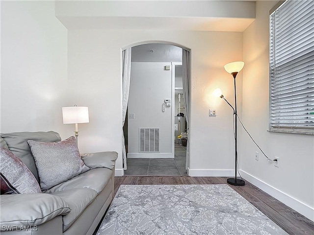 1732 Tarpon Bay Dr S Unit 101, Naples, FL 34119 - living room featuring arched walkways, wood finished floors, and baseboards