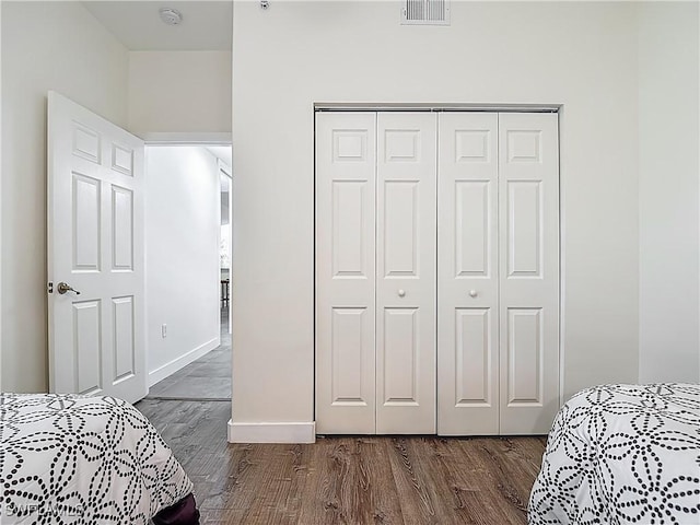 1732 Tarpon Bay Dr S Unit 101, Naples, FL 34119 - bedroom featuring a closet, dark wood finished floors, and baseboards
