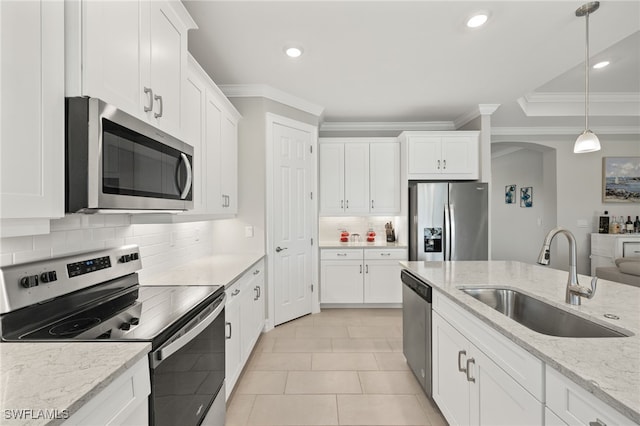 309 Spiaggio Ct, Naples, FL 34114 - kitchen with stainless steel appliances, a sink, crown molding, white cabinets, and tasteful backsplash