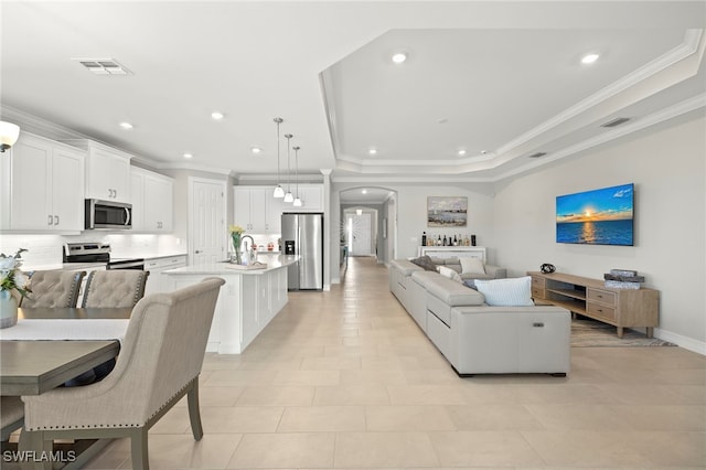 309 Spiaggio Ct, Naples, FL 34114 - living area with crown molding, arched walkways, recessed lighting, a raised ceiling, and baseboards