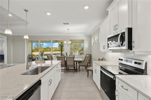 309 Spiaggio Ct, Naples, FL 34114 - kitchen featuring appliances with stainless steel finishes, a sink, crown molding, decorative backsplash, and white cabinets